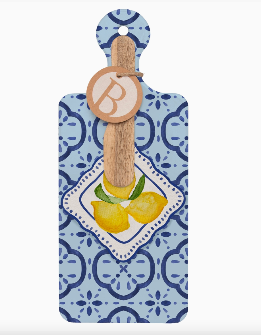 Decorative cutting board with lemon design and wooden handle on a blue patterned card.