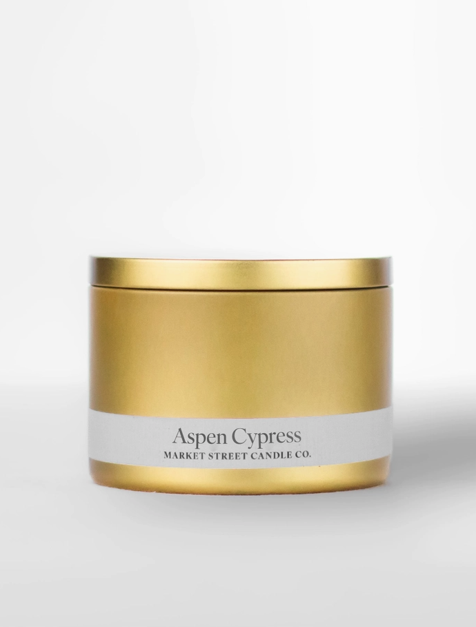 Market Street Candle Co. Aspen Cypress 8 oz Travel Tin soy candle in a sleek gold metal tin with matching lid and white label.