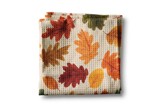 Waffle-textured towel with autumn leaf pattern on a white background