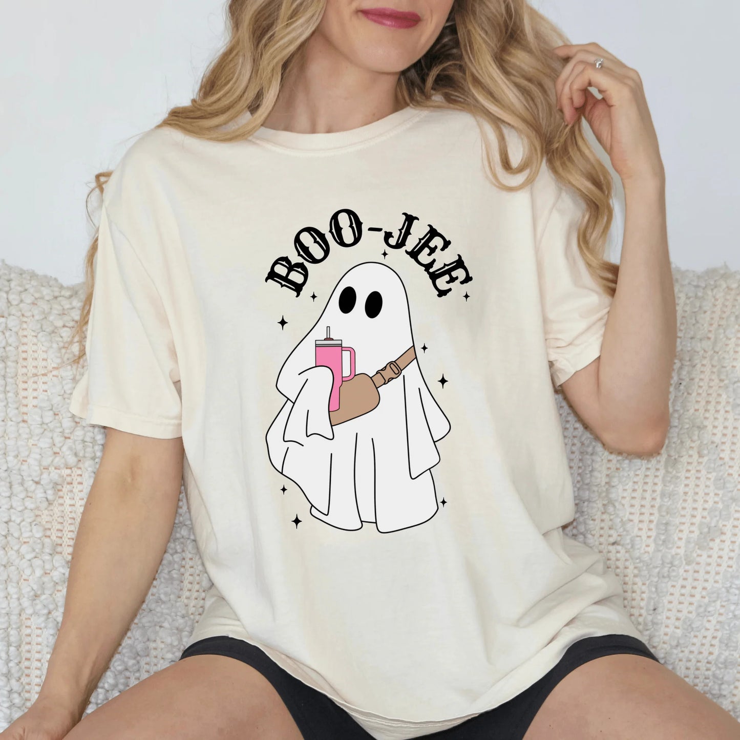 Person wearing a white t-shirt with a ghost holding a book and 'BOO-JEE' text.