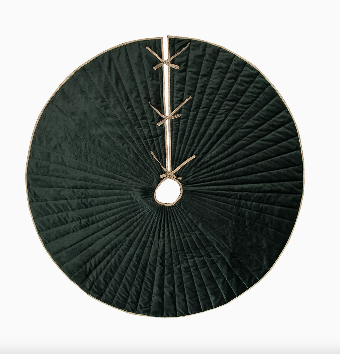 Round 54-inch emerald green velvet Christmas tree skirt with radiating quilted stitching, gold trim, center opening, and three gold ribbon tie closures.