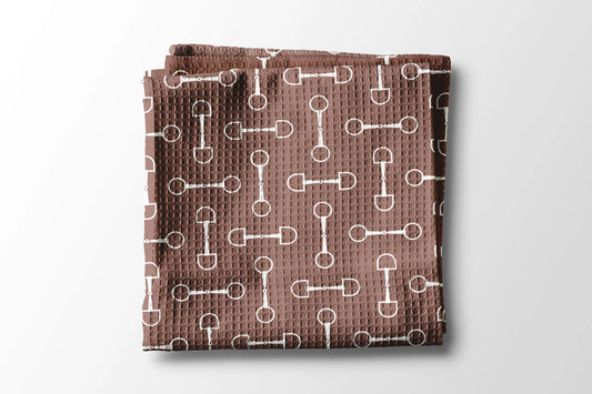 Brown towel with white pattern on a light gray background