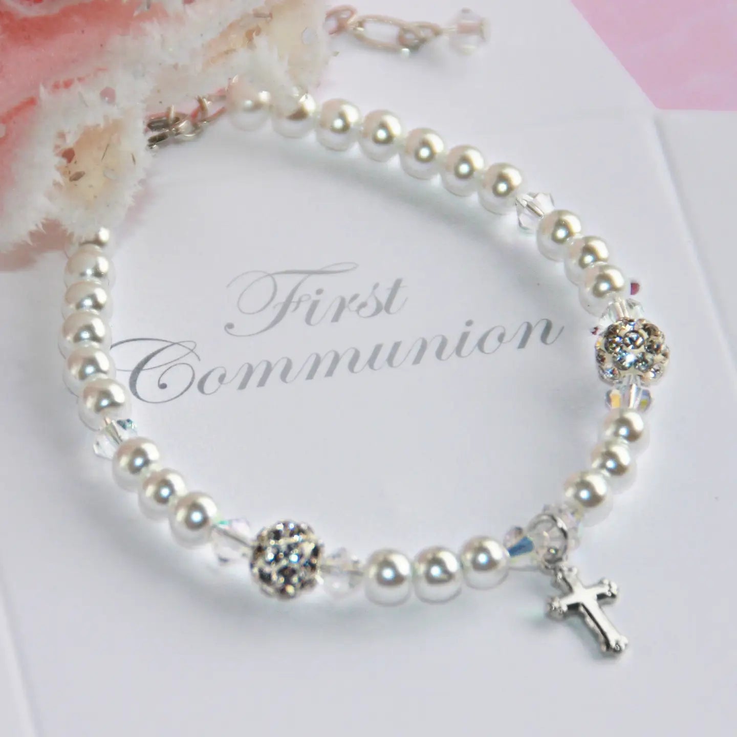 Pearl bracelet with a cross charm on a 'First Communion' card