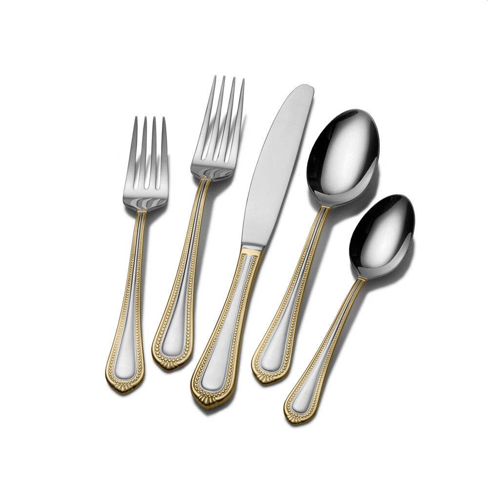Set of silver cutlery with gold accents on a white background