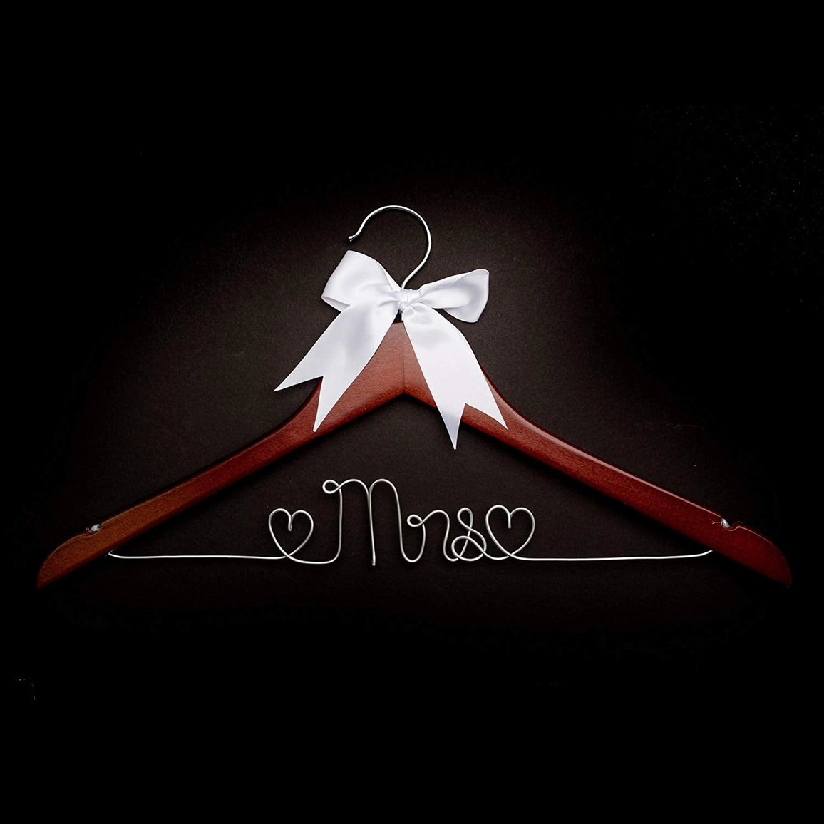 Wooden hanger with a white bow and 'Mrs.' inscription on a black background
