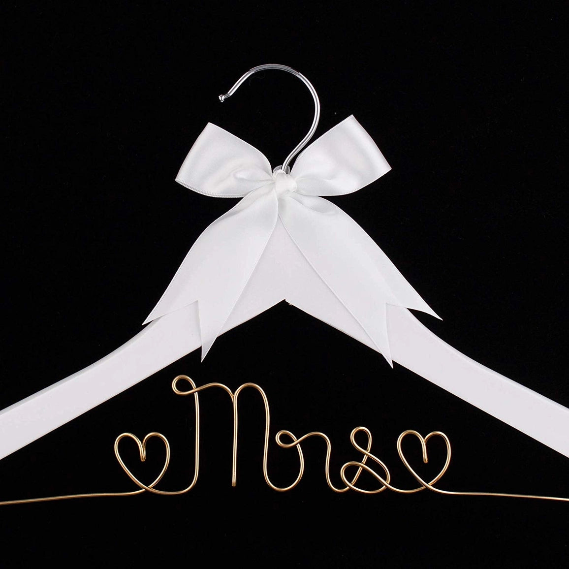 White hanger with a gold 'Mrs.' inscription and a white bow on a black background