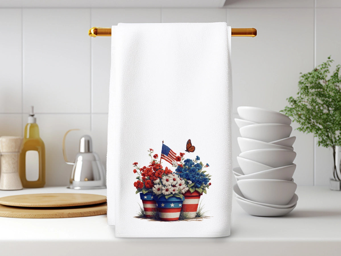 Kitchen towel with floral design and American flag hanging on a wooden rod.