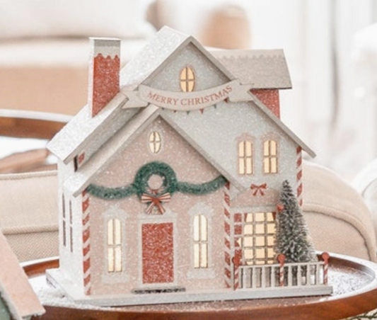 Decorative Christmas house with lights on a table