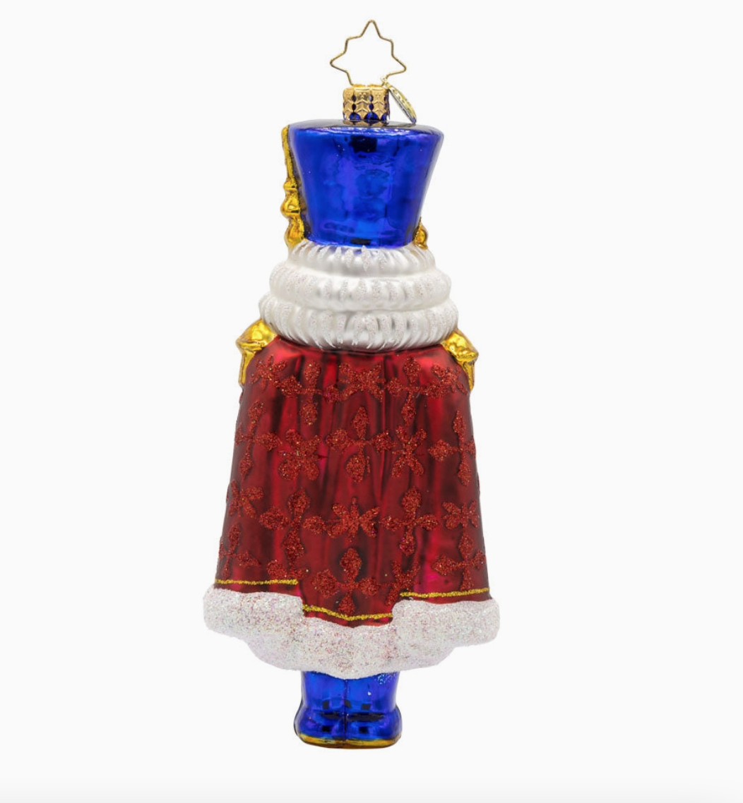 Back of Christopher Radko Long Coat Nutcracker glass ornament with glittered red cape and royal blue hat