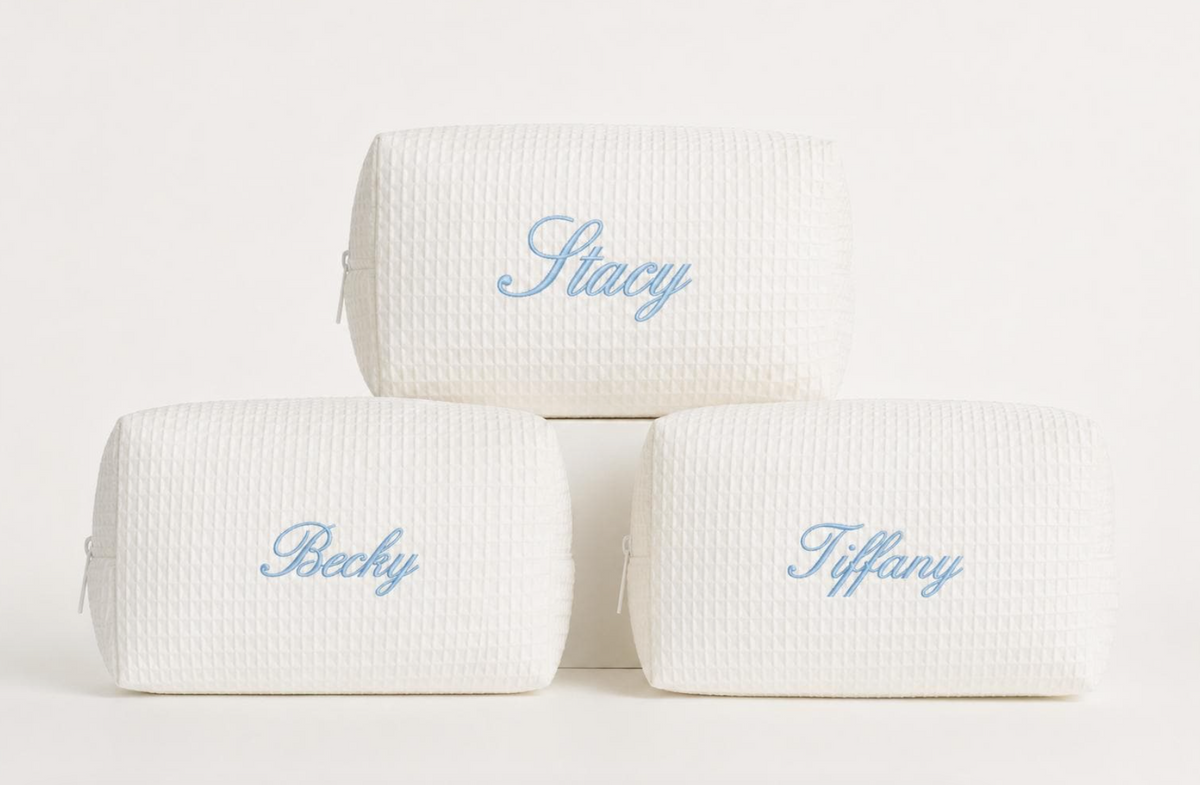 Personalized cream waffle cosmetic bags with embroidered names in light blue thread