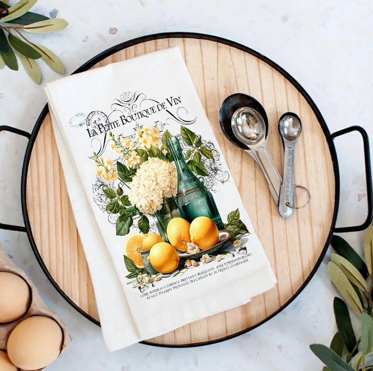 Book titled 'La Petite Boutique de Vin' with lemons and measuring spoons on a wooden board with lemons.
