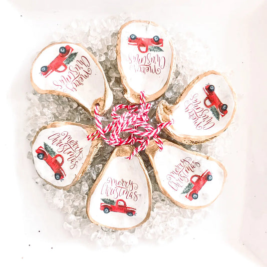 Decorative ornaments Made from Oyster shells with a red Christmas Truck design and text on a white background