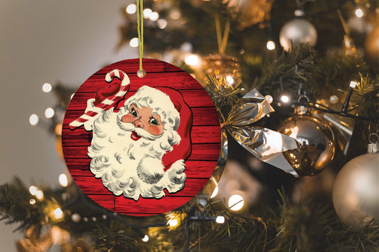 Christmas ornament with Santa Claus on a red background hanging on a decorated tree.