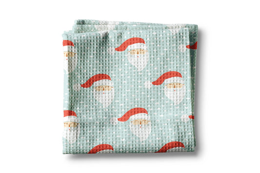Waffle-textured blanket with Santa Claus pattern on a light green background