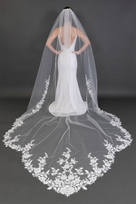 Bride wearing 120 inch white cathedral wedding veil with wide floral lace train