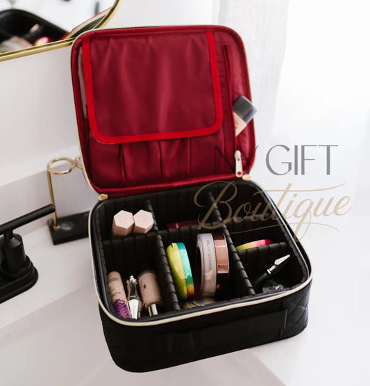 Black makeup case with red interior, containing various makeup items, on a white surface.