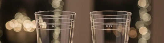 Two clear champagne flutes with silver bases on a white background