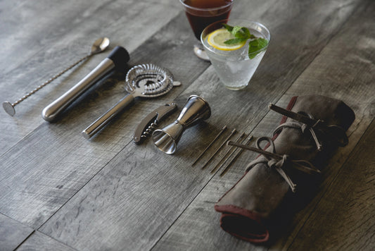 Bar tools and ingredients on a wooden surface