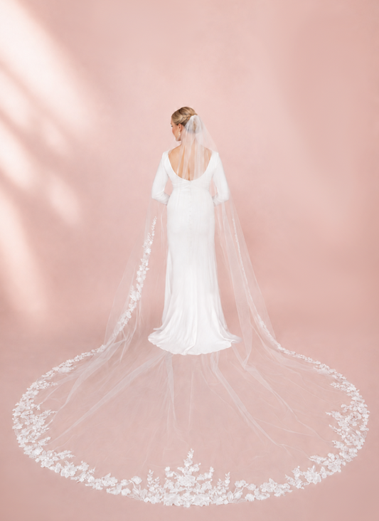 Bride wearing 120-inch ivory cathedral wedding veil with trailing floral lace and dramatic wide train
