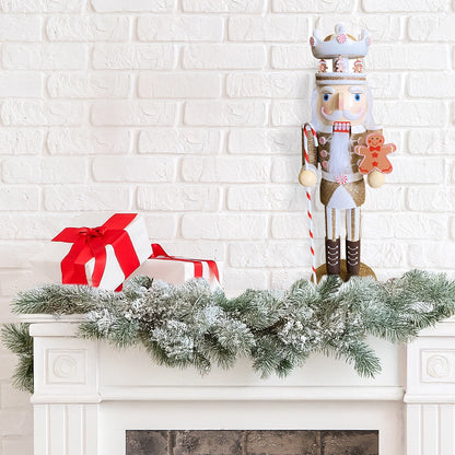 Decorative nutcracker with a gingerbread man on a mantel with a white brick wall background.