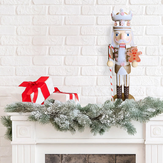 Decorative nutcracker with a gingerbread man on a mantel with a white brick wall background.