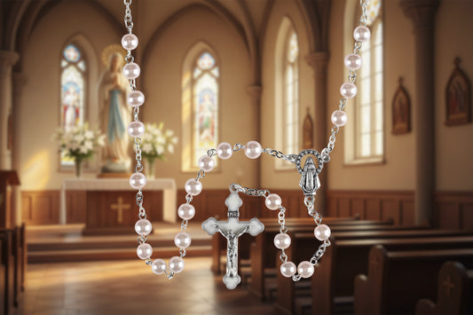 Pearl rosary with silver cross on a white background