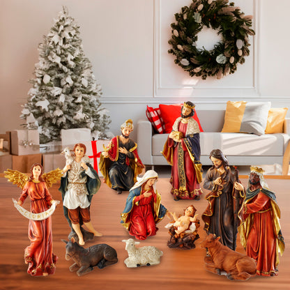 A Christmas nativity set with multiple figurines including Mary, Joseph, baby Jesus, angels, shepherds, wise men, a camel, and a sheep, arranged on a wooden table in a decorated living room with a Christmas tree, wreath, and sofa in the background.