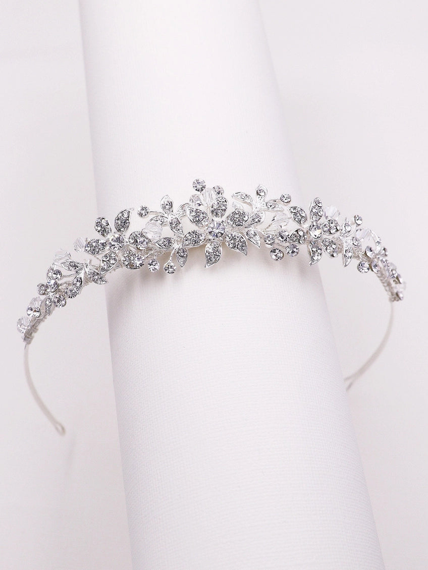 Silver tiara with intricate design on a white background