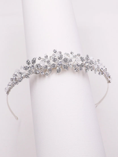 Silver tiara with intricate design on a white background