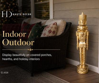 A tall decorative gold nutcracker stands on a wooden porch beside a dark wicker outdoor chair with patterned pillows. Text on the left reads 'HD HAUTE DECOR' and 'Indoor / Outdoor', with additional copy about displaying decor on covered porches and hearths.