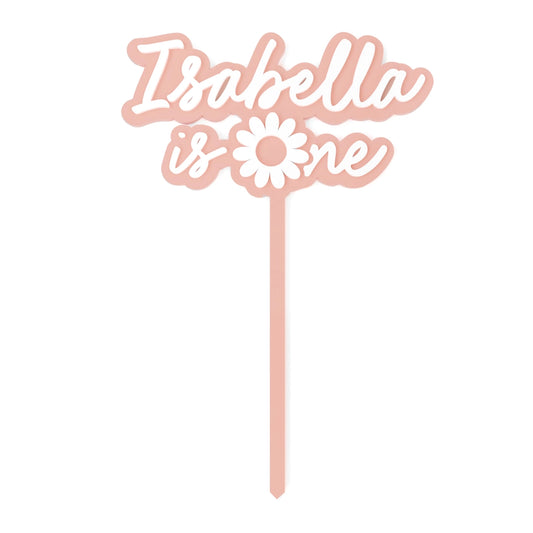 Decorative cake topper with 'Isabella is one' text and a flower design on a white background