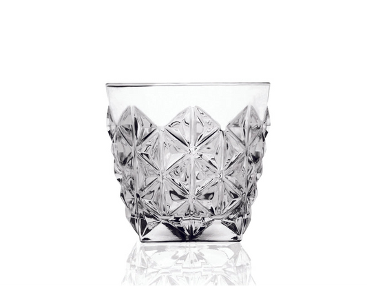 Clear glass tumbler with diamond cut pattern on a white background