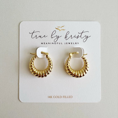 Gold hoop earrings on a 'true by kristy' branded card.
