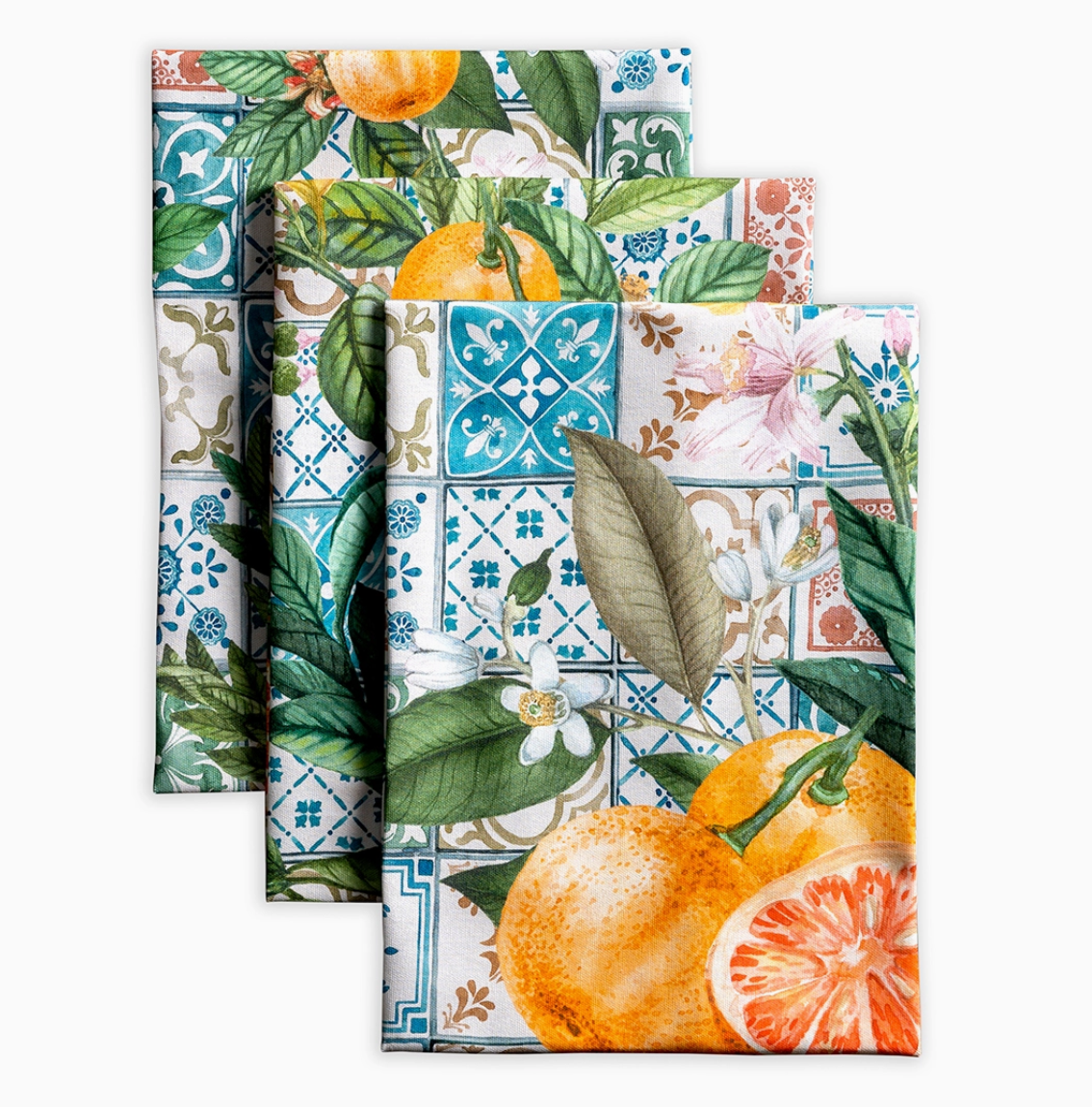 Set of three decorative napkins with floral, tile, and citrus designs on a white background.
