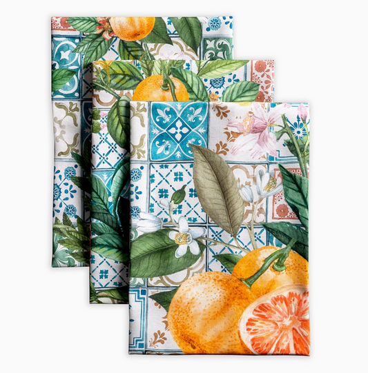 Set of three decorative napkins with floral, tile, and citrus designs on a white background.