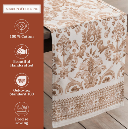 Decorative table runner with intricate patterns on a wooden surface, featuring branding and certification details.