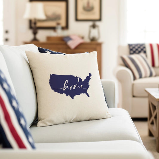 Decorative pillow with 'home' and USA map design on a couch in a living room setting.