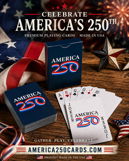 Playing cards with 'America 250' design on a wooden surface with American flag and star decorations.