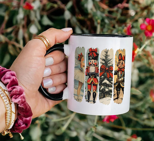 Hand holding a mug with decorative illustrations of a nutcracker and trees against a floral background.