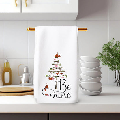 Kitchen towel with Christmas tree design and text hanging on a rack in a kitchen.