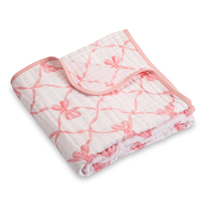 Folded baby blanket with pink floral pattern on a white background