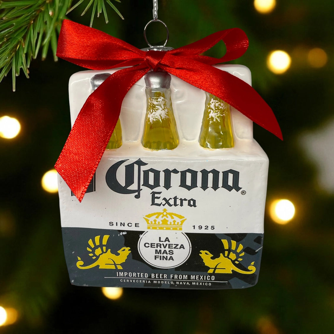 Corona Extra beer six-pack ornament with a red ribbon on a Christmas tree.