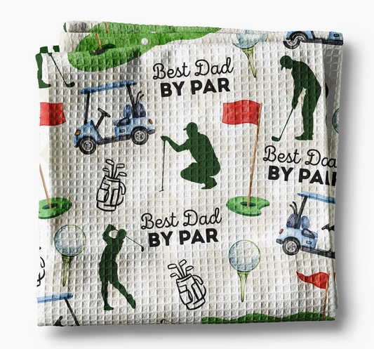 Golf-themed kitchen towel with 'Best Dad By Par' text and golf-related illustrations on a white background.