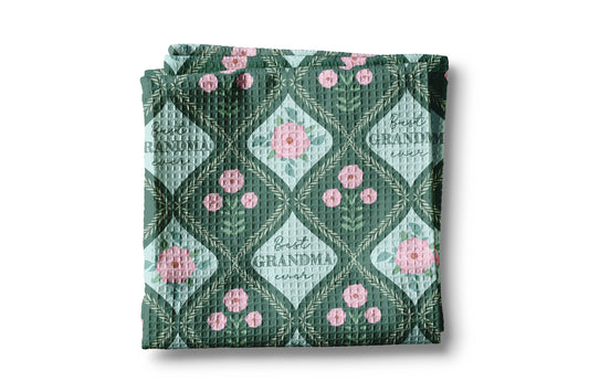 Folded quilt with floral pattern and 'Best Gigi Ever' text on a white background