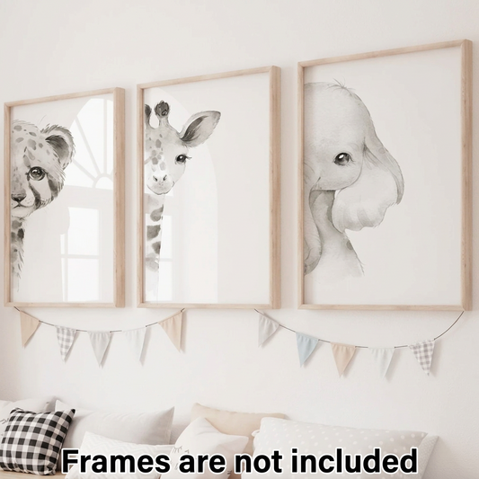 Set of three black and white watercolor safari nursery wall art prints featuring a spotted big cat, giraffe, and elephant peeking into natural wood frames above a neutral nursery bed.