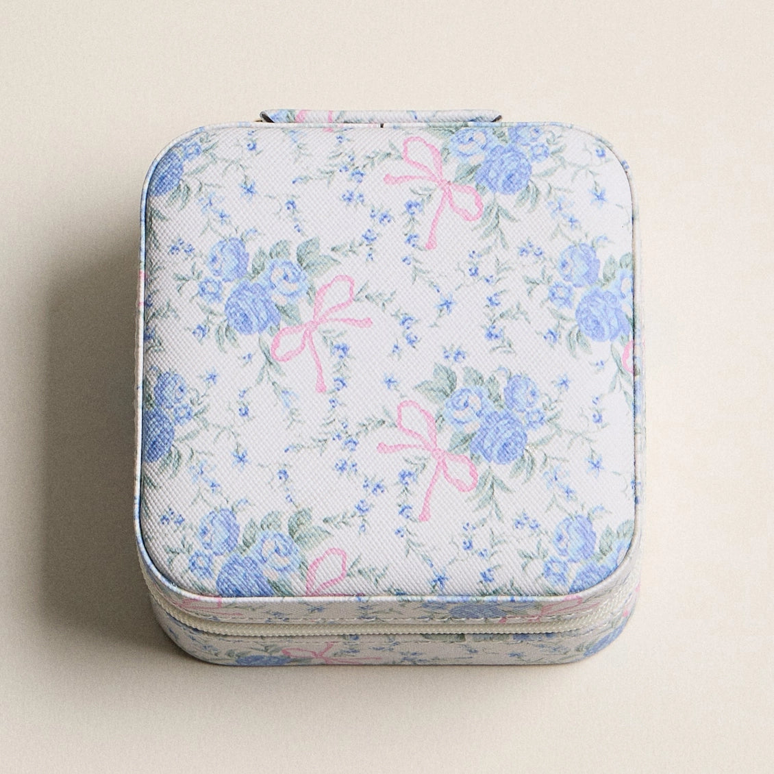 Floral patterned case with pink bows on a beige background