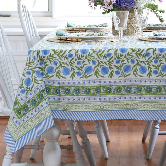 Table setting with a floral patterned tablecloth on a wooden table.