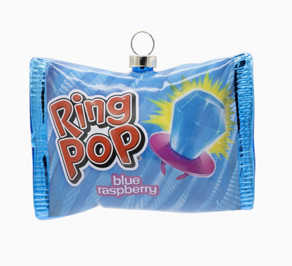 A blue Ring Pop candy bag shaped like a small purse or clutch, with a silver hanging loop at the top. The front shows the Ring Pop logo, a blue gem illustration, and the text 'blue raspberry'.
