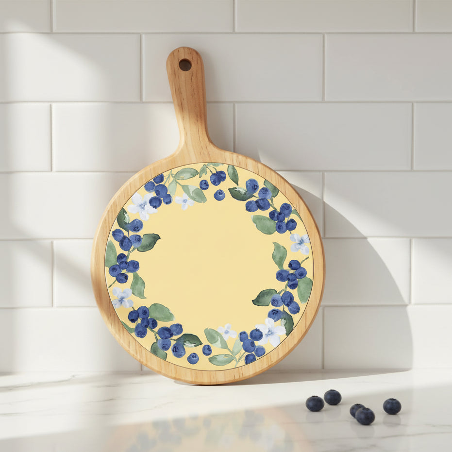 Round wooden cutting board with floral design on a yellow background