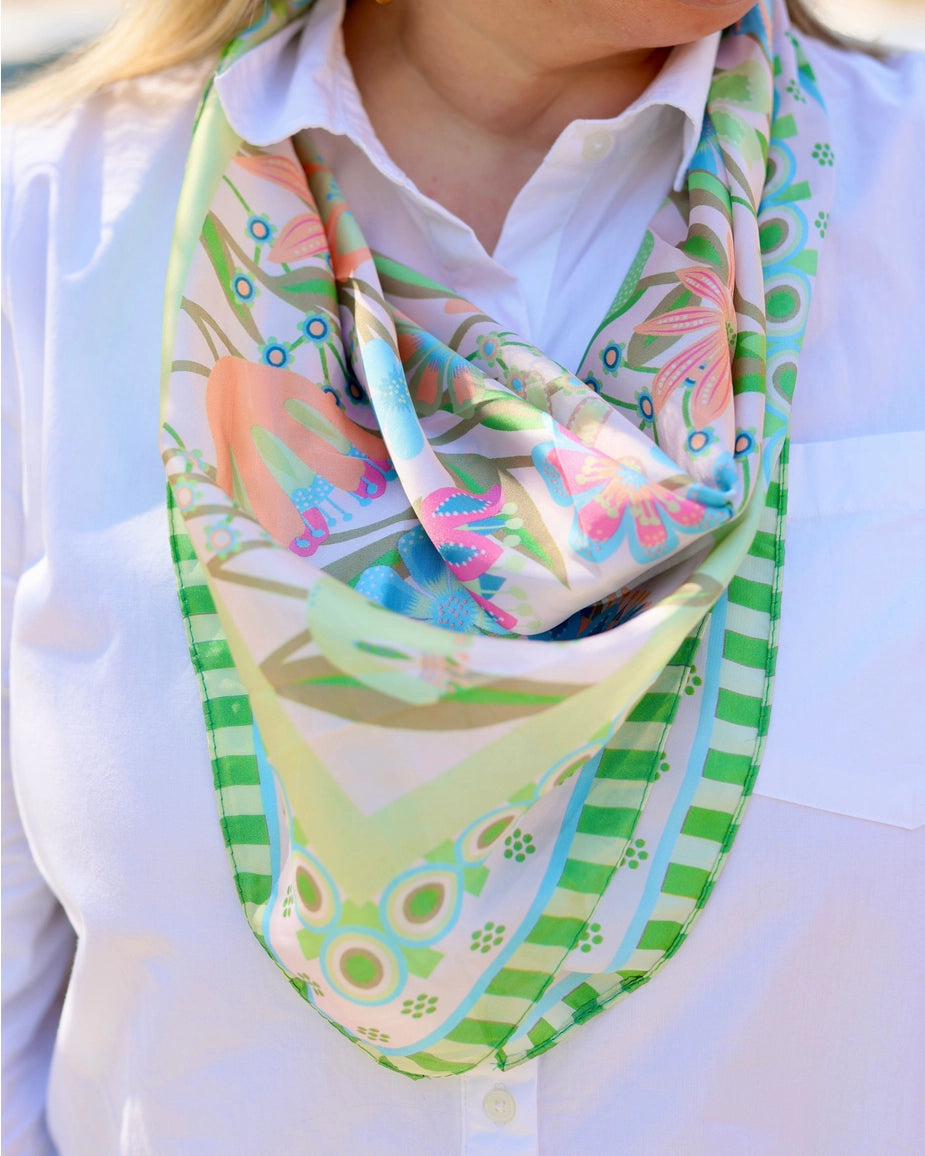 Colorful patterned scarf worn by a person on a white background